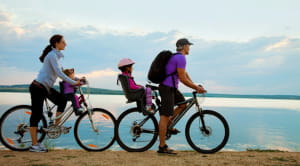 Young family cycling on coast